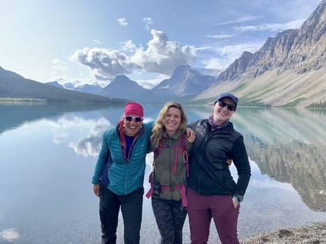 Smiling guides posing in front of mountain lake